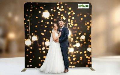 Miri pozând elegant în fața unui fundal de cabină foto profesional. Decorul este întunecat, cu un model bogat de luminițe bokeh aurii