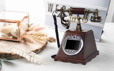 Un mod unic de a păstra amintirile nunții: video guestbook integrat într-un telefon vintage din lemn și bronz. Este așezat într-un decor romantic de nuntă, pregătit să înregistreze mesajele video și urările emoționante ale invitaților in București și Ilfov